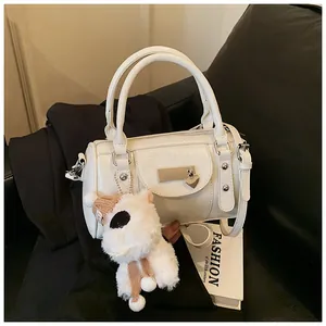 Detail der weißen Mini-Bowlingtasche mit silbernem Herzanhänger und Schaf-Anhänger