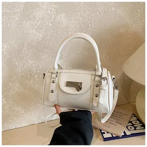 Detail der weißen Bowling-Tasche aus Leder mit Herzanhänger und Metallschnalle