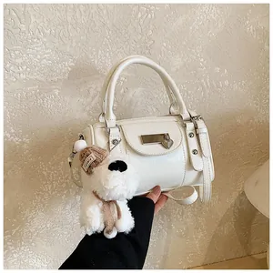 Detail der weißen Mini-Boston-Tasche mit Herzanhänger und Plüschhund-Anhänger