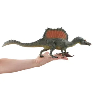 Realistic Spinosaurus dinosaur toy model with red sail fin held in hand for scale