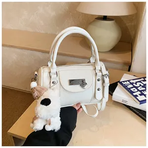 Nahaufnahme der weißen Boston-Tasche mit Lychee-Struktur und süßem Plüschtier-Anhänger