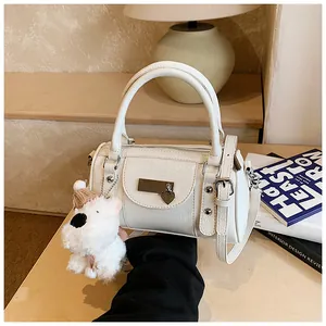 Detailansicht der weißen Boston Tasche mit Plüsch-Hundeanhänger und Metall-Herz-Deko