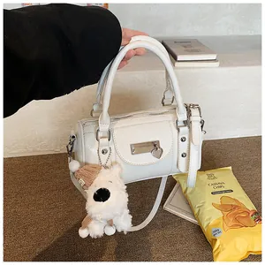 Detailansicht der weißen Bowling-Tasche mit Herzanhänger und kleinem Plüschwelpen