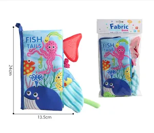 Detail view of Fish Tails baby cloth book with 3D tactile tails and packaging measurements