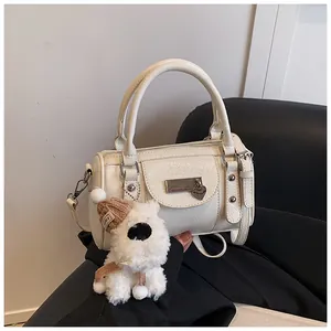 Detail der cremeweißen Bowlingtasche aus Leder mit Plüsch-Anhänger und Silber-Hardware