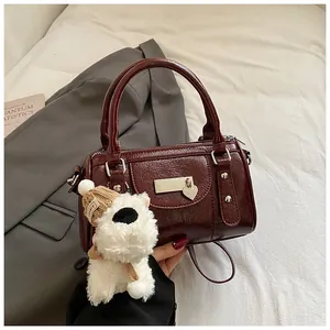 Detailansicht der weinroten Lackleder-Tasche mit silbernem Herzdekor und süßem Anhänger