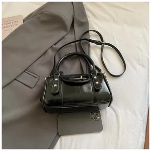 Detailansicht der schwarzen glänzenden Bowling Bag mit Nieten und Smartphone zum Größenvergleich