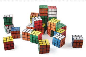 High-angle view of multiple classic 3x3 speed cubes stacked on a white surface