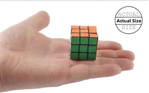 Actual size comparison of a mini 3x3 magic cube held in a person's palm on white background