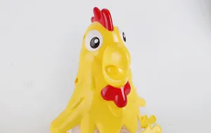 Close-up of a yellow cartoon chicken toy with red comb and smooth plastic finish