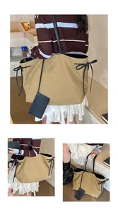 Detail view of khaki canvas tote bag with black bow ribbons and a small zipper pouch