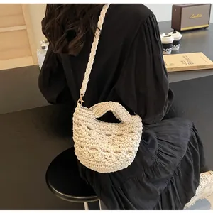 Detail of hollow woven cotton beach bag showing cream crochet pattern and metal ring
