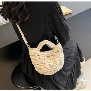 Detail of beige crochet bucket bag with hollow knit texture and gold metal hooks