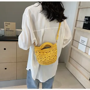 Detail of yellow hand-woven cotton crossbody bucket bag with floral crochet pattern
