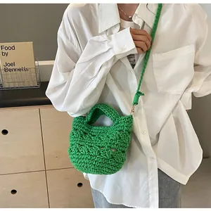 Detail of hand-woven green cotton bucket bag with large crochet knit texture and strap