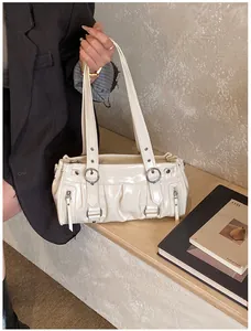 Detail der cremefarbenen Schultertasche mit Metallringschnalle und Seitenreißverschlüssen