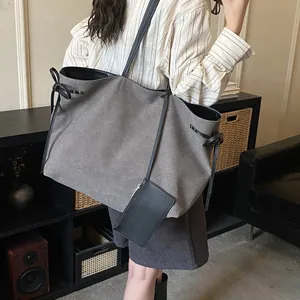 Large khaki canvas tote bag with black ribbon bow detail and matching small pouch