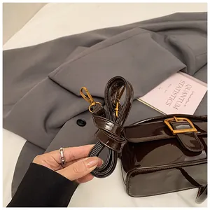 Detail der dunkelbraunen Lackledertasche mit Gold-Schnalle und abnehmbarem Gurt