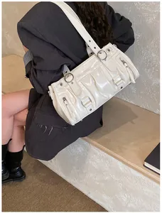 Detailansicht der cremefarbenen Schultertasche aus Lackleder mit Silberringen