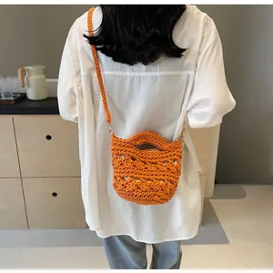 Detail of vibrant orange hand-woven bucket bag with textured crochet knit and braided strap
