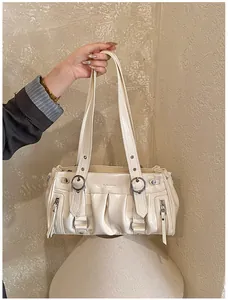 Nahaufnahme der cremeweißen Faltenhandtasche mit Glanzeffekt und Schnallendetails
