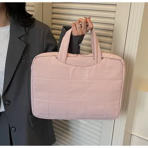 Detail of pink quilted laptop bag with double zippers and top handle for commuting