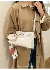 Chic cream white leather crossbody bucket bag set shown on a vintage trench coat model