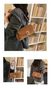 Detail of a brown leather shoulder bag with a rectangular gold buckle for women