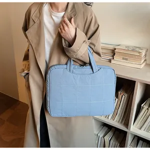 Close-up of light blue quilted nylon tote bag with front pocket for daily commute
