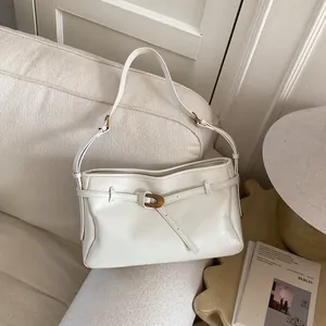 Retro large capacity cream shoulder bag with vintage buckle on soft textured sofa