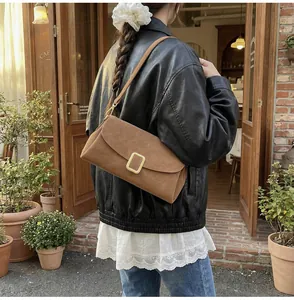 Outdoor lifestyle shot of a brown vintage satchel bag with a large gold metal buckle detail