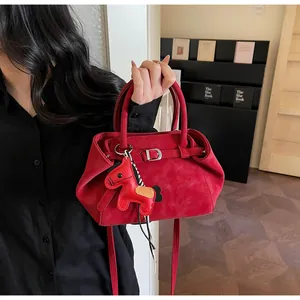 Detail der roten Wildleder-Handtasche mit Rundgriffen und Pferde-Anhänger