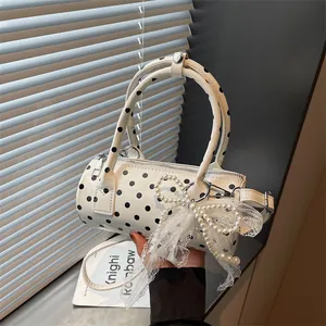 Polka dot cylinder handbag with mesh bow and pearl pendant in white patent leather