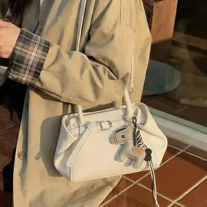 Schicke beige Tragetasche mit Pferdeanhänger an einem stilvollen Model im Trenchcoat