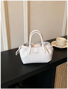 Close-up of cream white tote bag featuring pebble leather texture and fashion lettering
