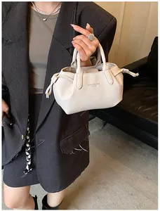 Detail of cream lychee leather tote bag with dual handles and drawstring sides