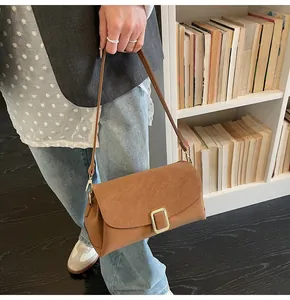 Detail of vintage brown shoulder bag with golden buckle and premium matte texture