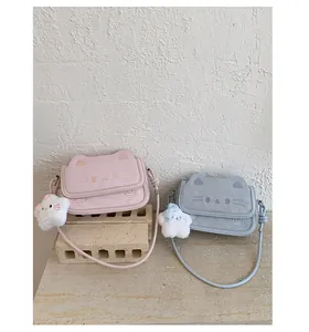 Detail showing pink and blue cat-shaped crossbody bags with cute embroidery and fur charms