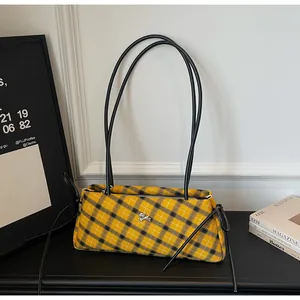 Close-up of yellow and black checkered canvas tote bag with leather straps and silver dog charm