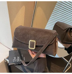 Detailed close-up of a vintage coffee brown suede crossbody bag with gold square buckle