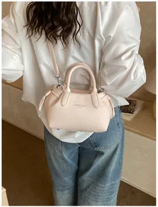 Detailed shot of pink leather tote bag featuring crossbody strap and side drawstring