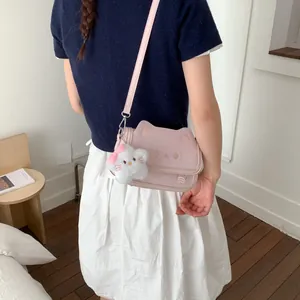 Cute pink cat-shaped crossbody bag with 3D ears and plush kitten charm accessory