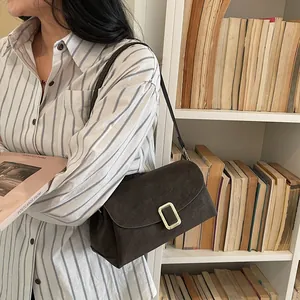 Retro dark brown crossbody bag with gold metal buckle shown in a lifestyle setting