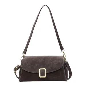 Retro dark brown crossbody pillow bag with gold rectangular buckle and matte texture