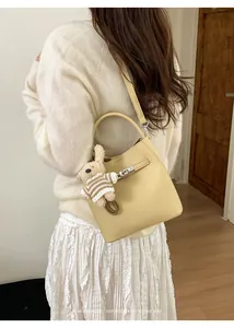Detailansicht der gelben Leder-Eimertasche mit Schloss und Kaninchen-Anhänger
