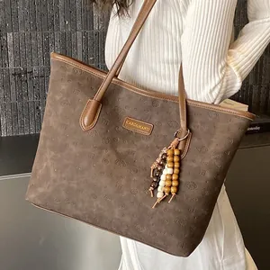Retro brown leather tote bag with bear embossing and wooden bead charm on shoulder strap