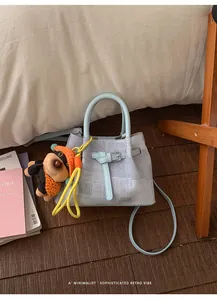 Light blue textured bucket bag with metal buckle and cute plush dog pendant charm