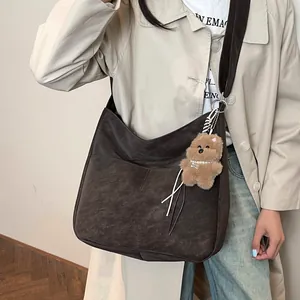 Sac fourre-tout marron foncé mat avec pendentif ours en peluche porté par mannequin