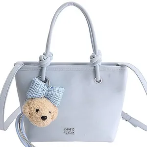 Sac bandoulière bleu clair minimaliste avec poignées nouées et un joli pendentif d'ours