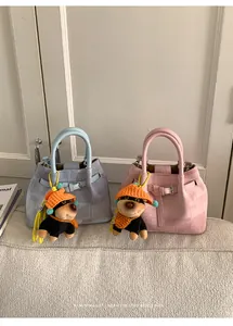 Detail of light blue and pink fabric bucket bags with cute puppy charms and leather straps